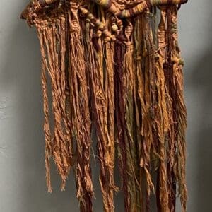 A brown and tan colored yarn hanging from the ceiling.