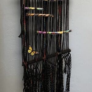 A wall hanging with black cords and beads.