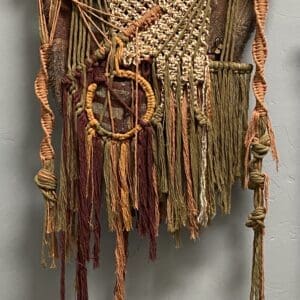 A wall hanging made of yarn and rope.