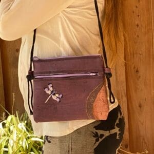 A woman is holding onto her purse and looking at the camera.