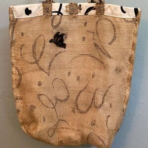 A bag hanging on the wall with some writing