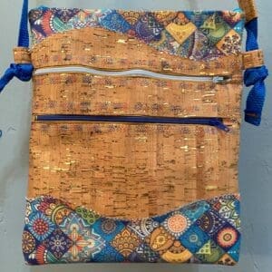 A bag with a blue strap and some colorful tiles