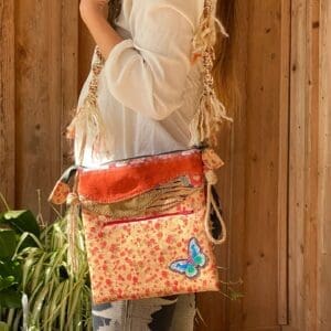 A woman is holding onto the strap of her purse