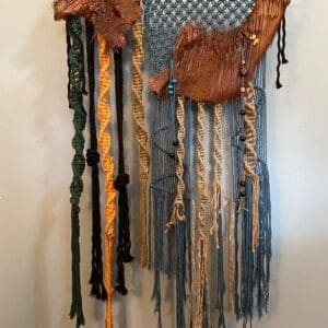 A wall hanging made of leather and yarn.