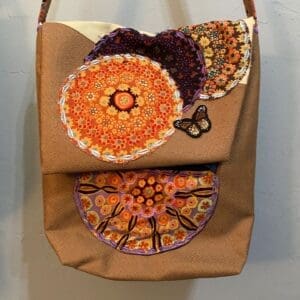 A brown bag with some orange and purple designs on it