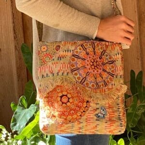 A person holding onto a bag with a sun design on it