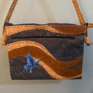 A bag with a butterfly on it hanging from the wall.