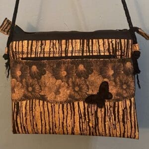 A brown and black purse hanging on the wall
