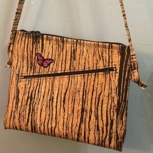 A wooden purse with a butterfly on it.